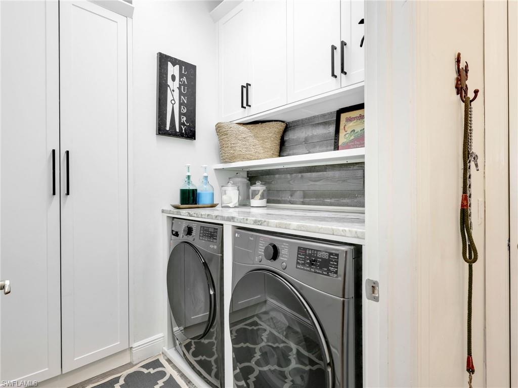 4743 Abaca Circle Naples, FL 34119 - Photo 37 of 50 Laundry area with cabinet space and washing machine and dryer