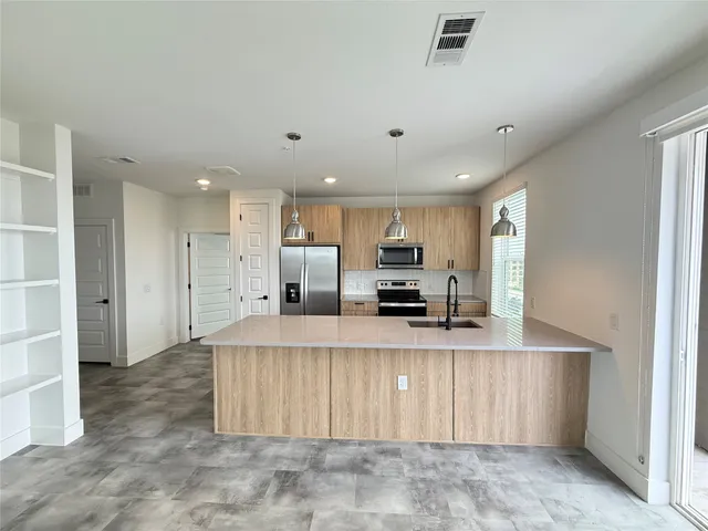 a large kitchen with stainless steel appliances lots of counter top space