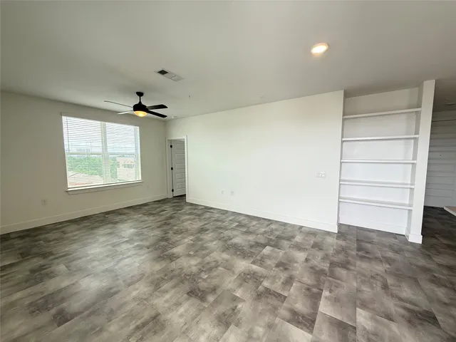 an empty room with windows and cabinet