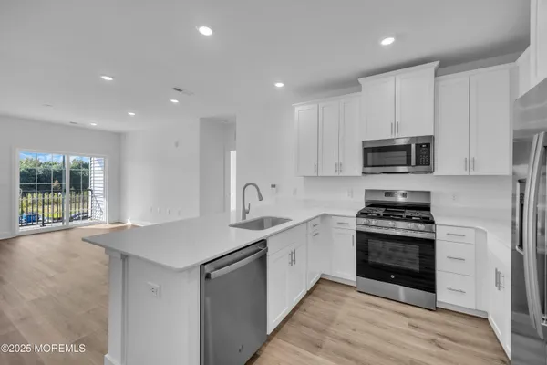 a kitchen with stainless steel appliances granite countertop a sink stove and microwave
