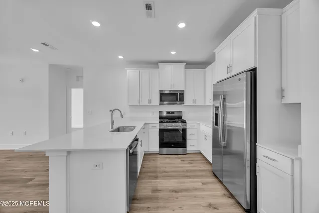 a kitchen with refrigerator a sink and wooden cabinets