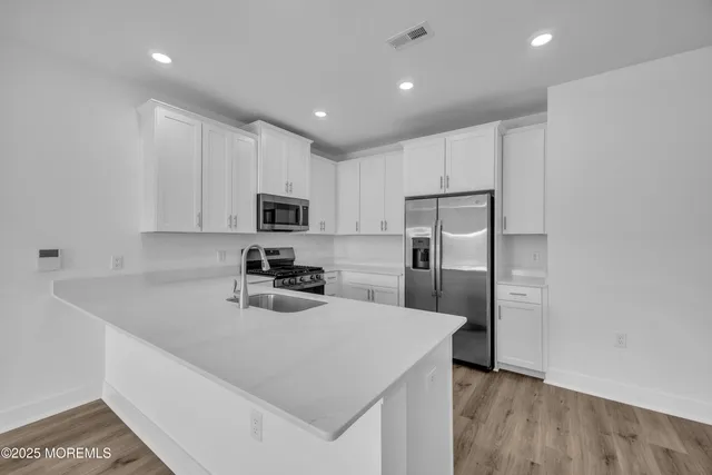 a kitchen with kitchen island a refrigerator sink and cabinets