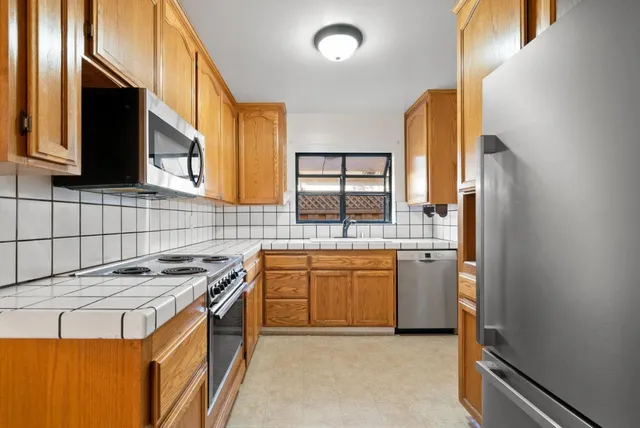 a kitchen filled counter top space a sink a stove and a refrigerator