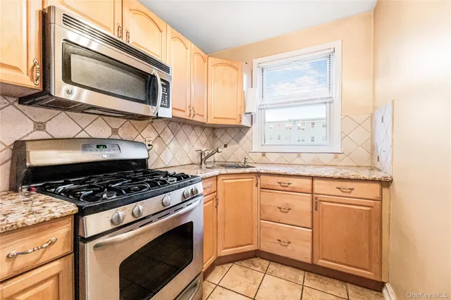 a kitchen with granite countertop cabinets stainless steel appliances and a window
