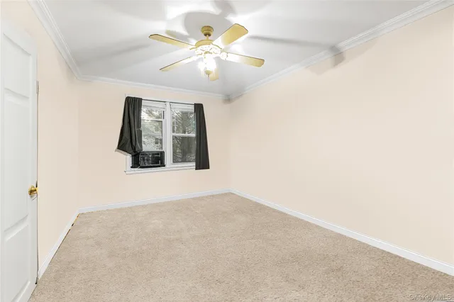 an empty room with a chandelier fan and windows