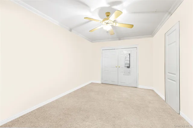 an empty room with a chandelier fan and windows