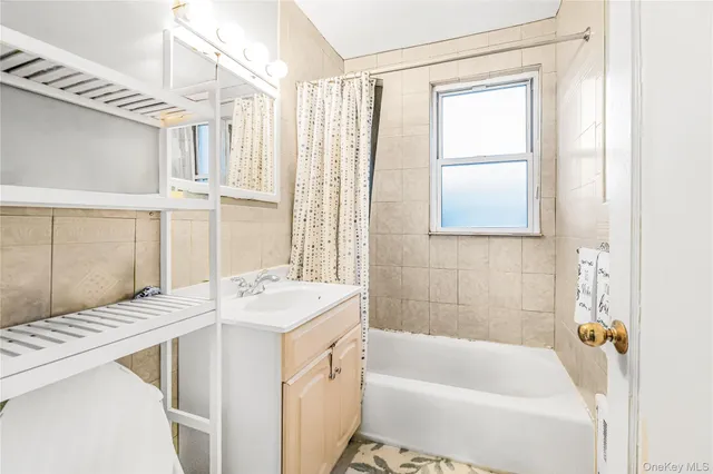 a bathroom with a tub sink and a window