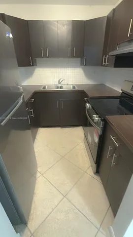 a kitchen with a stove top oven and cabinets
