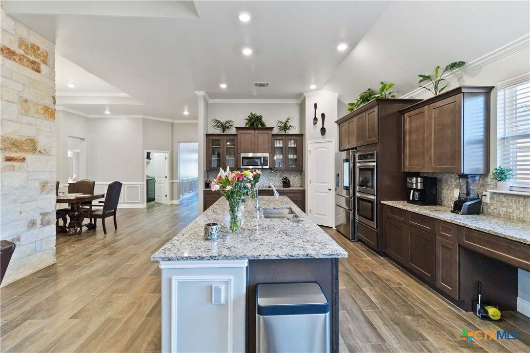 8402 Ridge Crest Drive Killeen, TX 76542 - Photo 11 of 34 a kitchen with stainless steel appliances granite countertop sink stove top oven and cabinets