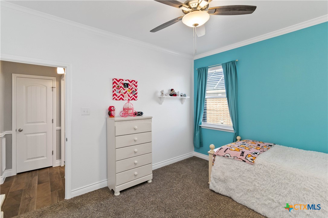 8402 Ridge Crest Drive Killeen, TX 76542 - Photo 26 of 34 a bedroom with a bed and a chandelier