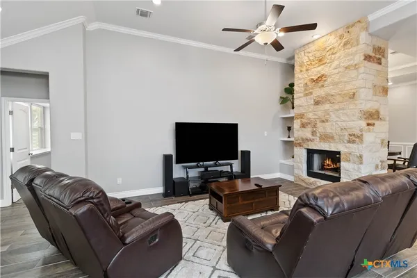 a living room with furniture a fireplace and a flat screen tv