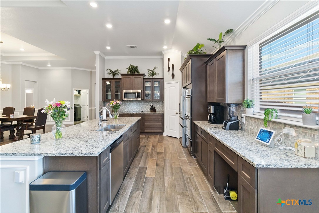 8402 Ridge Crest Drive Killeen, TX 76542 - Photo 10 of 34 a kitchen with granite countertop kitchen island stainless steel appliances a sink stove and refrigerator