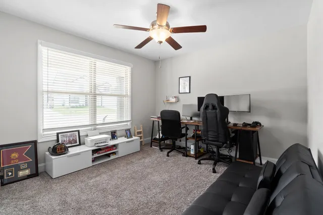 a view of a workspace with furniture and a window