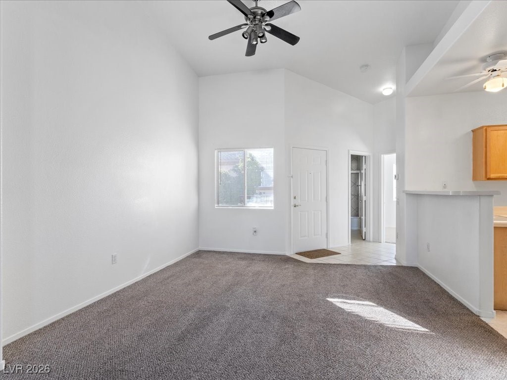 8725 West Flamingo Road, Unit 235 Las Vegas, NV 89147 - Photo 7 of 22 Unfurnished living room with a ceiling fan, high vaulted ceiling, and light carpet