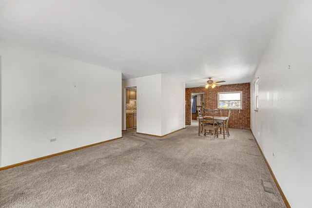a view of a livingroom with chairs and bench in kitchen