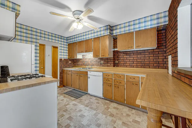 a kitchen with cabinets stove top oven and sink