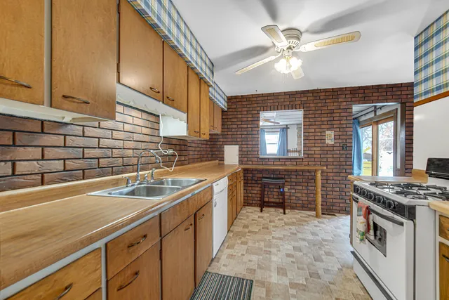 a kitchen with stainless steel appliances granite countertop a sink stove and cabinets