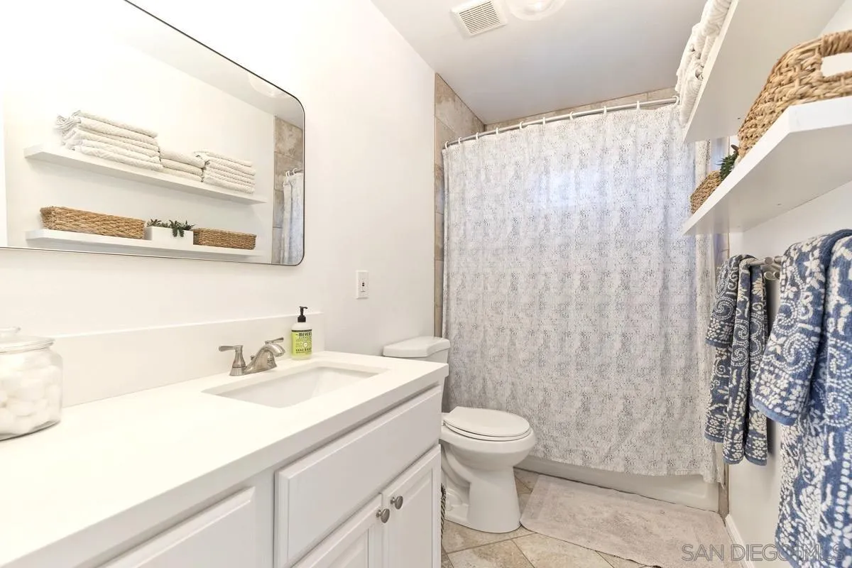 1448 Third Street Coronado, CA 92118 - Photo 17 of 30 a bathroom with a sink a toilet and shower curtain