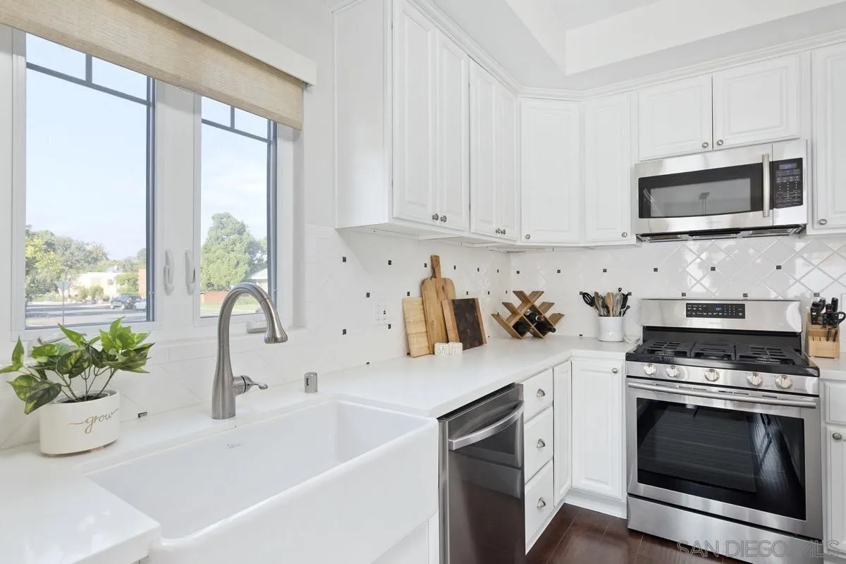 1448 Third Street Coronado, CA 92118 - Photo 6 of 30 a kitchen with stainless steel appliances a white stove top oven and a white cabinets