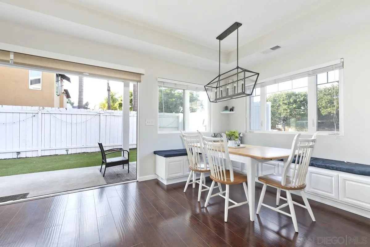 1448 Third Street Coronado, CA 92118 - Photo 8 of 30 a dining room with wooden floor a chandelier a glass table and chairs