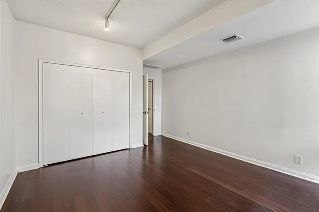 a view of an empty room with wooden floor