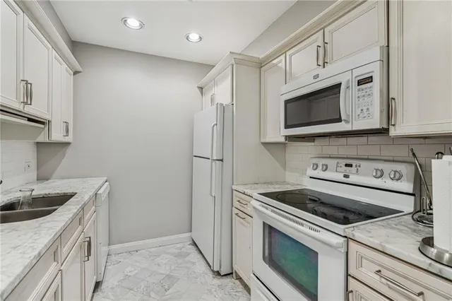 a kitchen with white cabinets sink and stainless steel appliances