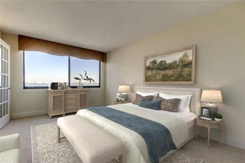 a spacious bedroom with a bed a couch and large window