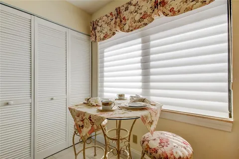 a view of a room that has a table and a chair in it