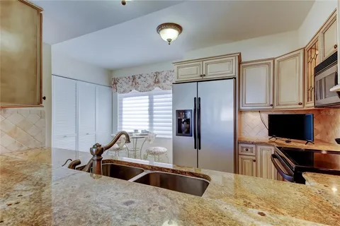 a kitchen with stainless steel appliances granite countertop a sink refrigerator and microwave