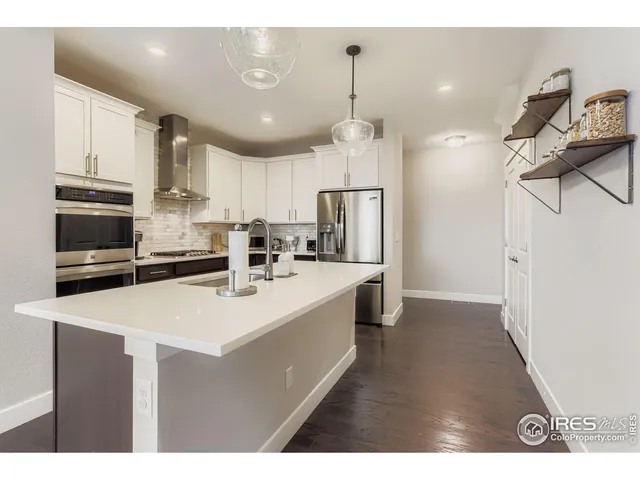 a kitchen with kitchen island a sink stainless steel appliances and refrigerator