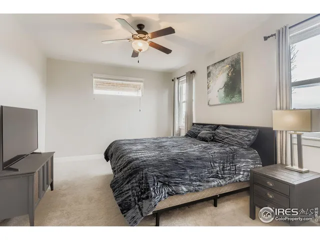 a bedroom with a bed window and a flat screen tv