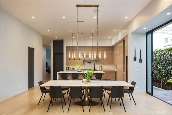 a dining room with stainless steel appliances a table and chairs