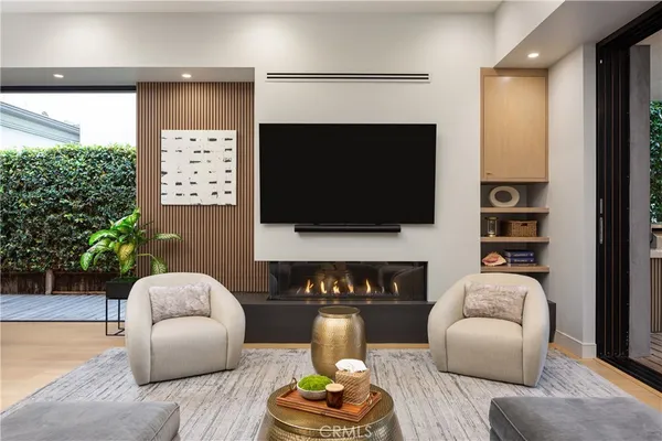 a living room with furniture a flat screen tv and a fireplace