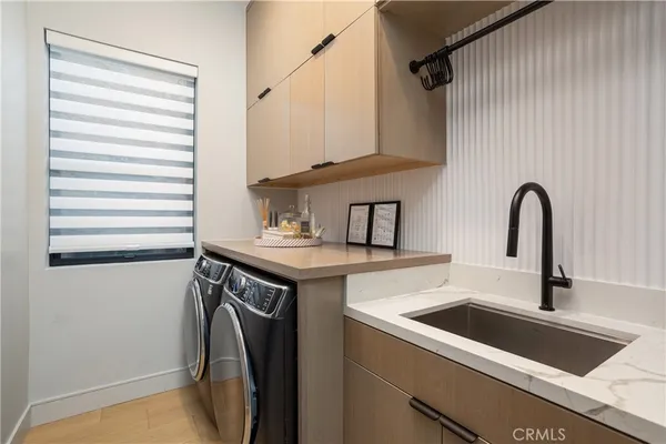 a utility room with sink dryer and washer