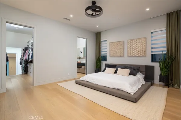 a bedroom with a large bed and a chandelier