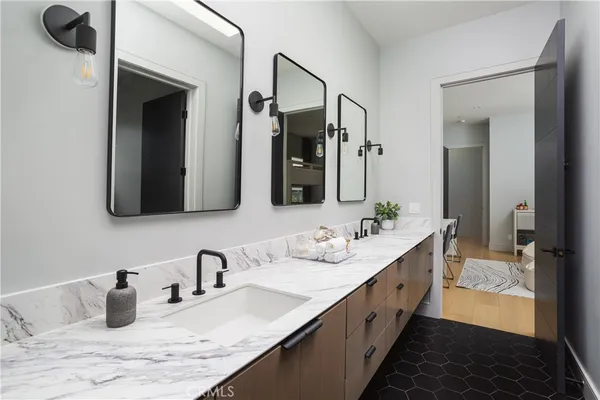 a bathroom with double vanity sinks and a mirror