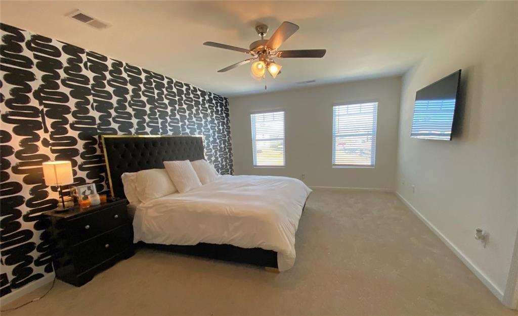 676 Whitman Lane Stockbridge, GA 30281 - Photo 16 of 50 a bedroom with a bed and a chandelier