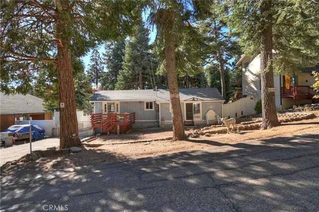 a view of a house with yard fire pit and a large tree