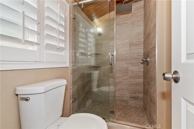 a bathroom with a toilet and a shower