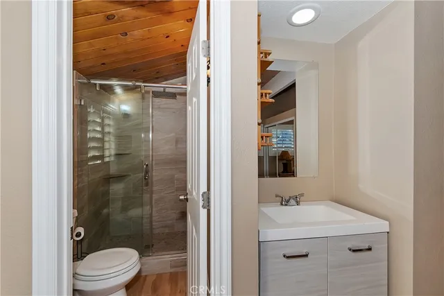 a bathroom with a shower sink vanity and toilet