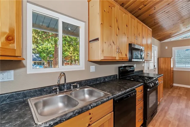 a kitchen with kitchen island granite countertop a sink stove and cabinets