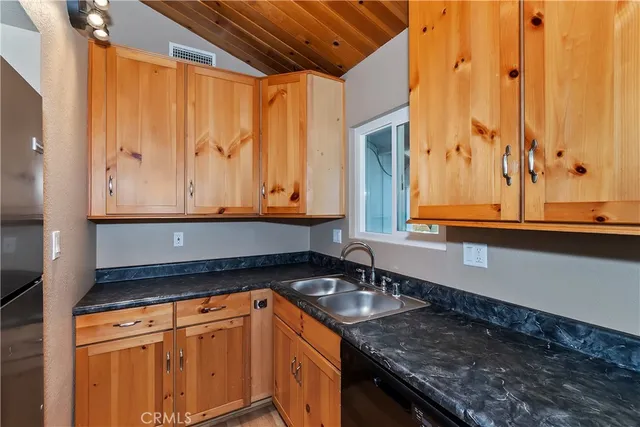 a kitchen with granite countertop sink and cabinets