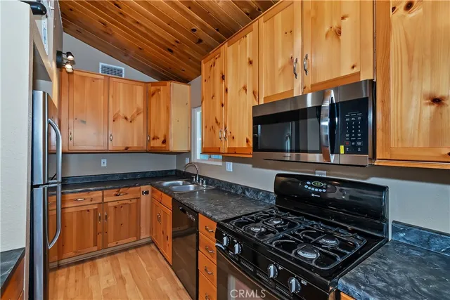 a kitchen with stainless steel appliances granite countertop a stove and a microwave