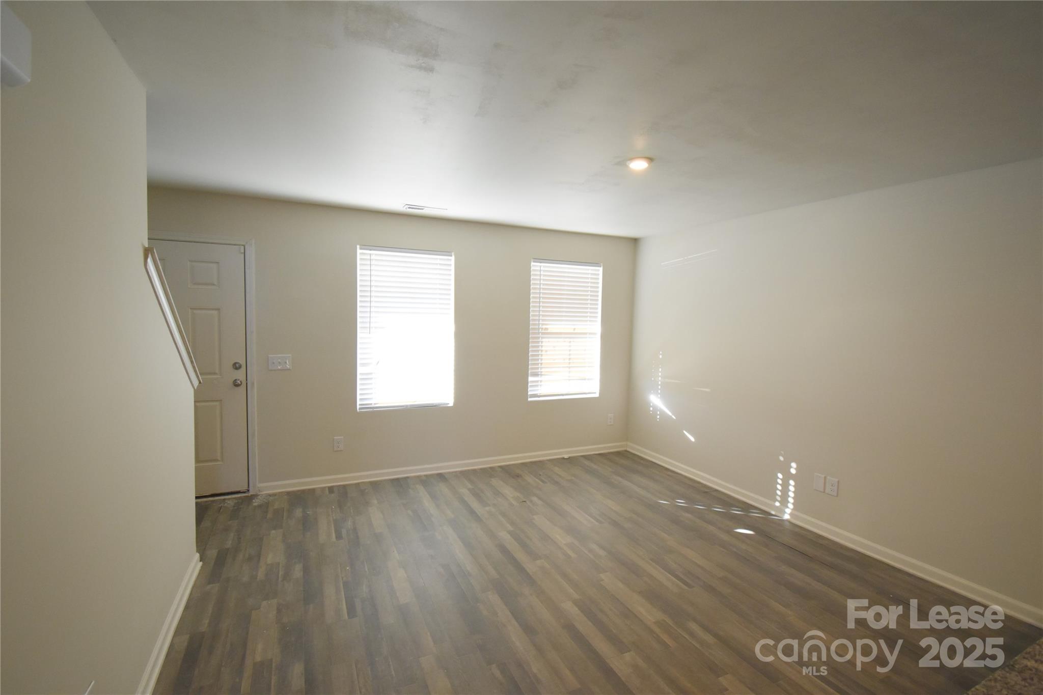569 Calvin Sowers Road Lexington, NC 27295 - Photo 4 of 20 an empty room with wooden floor and windows