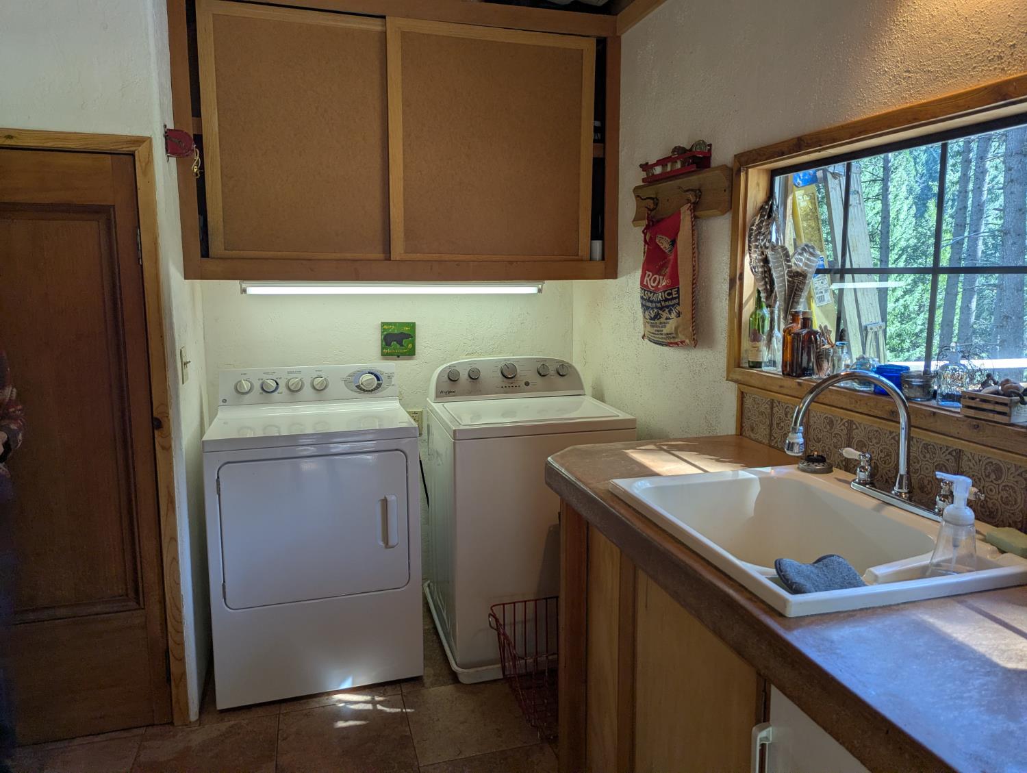 6105 Little Mountain Road Somerset, CA 95684 - Photo 11 of 21 laundry area featuring a textured wall, washer and clothes dryer, and cabinet space