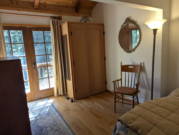 a view of a hallway with wooden floor and a mirror
