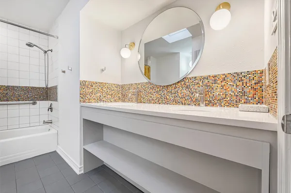 a bathroom with a mirror and a bathtub