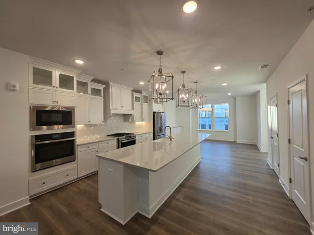 a kitchen with stainless steel appliances a refrigerator and a kitchen island