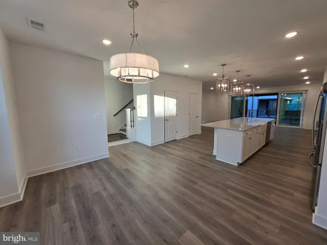 a view of a kitchen with a sink fridge and wooden floor