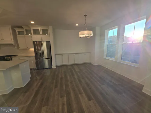 a view of an empty room with wooden floor and closet